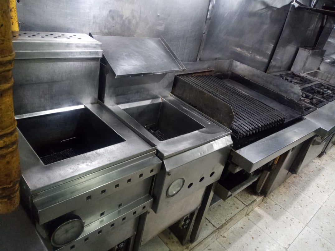 Operario realizando limpieza y desengrasado de campana de cocina industrial